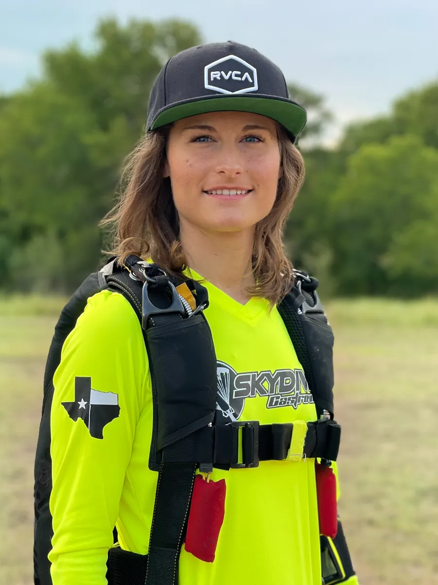 Daniella Santangelo in neon yellow Skydive Castroville shirt with skydiving harness